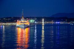 La Savoie paddle steamer arrives late, lit up in orange