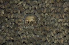 View of Catacombes de Paris featuring an underground passage lined with human skulls and bones