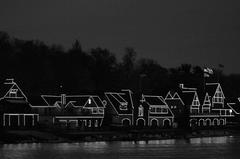 Boat houses illuminated at night along a waterway