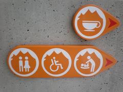 Icon signs outside the Redoubt of Lei Yue Mun Fort indicating the presence of a cafe and restrooms with handicapped access and changing tables