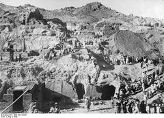 Excavation site in Thebes, Egypt with numerous local workers supervised by German and English scholars