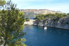 Aerial view of Cassis, France with buildings, green hills, and a harbor