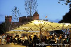 Place de La Victoire at dusk with the illuminated Castillet in the background