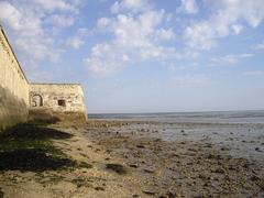 Walls of the citadel of Château d'Oleron on stony foreshore at low tide