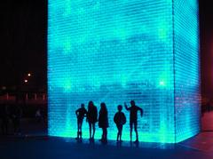 Tourists silhouetted against Crown Fountain at night