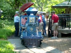 St Louis Zoo Railroad with visitors on board passing through a shaded area