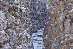 Narrow walkway in Chandigarh's Rock Garden between rock walls