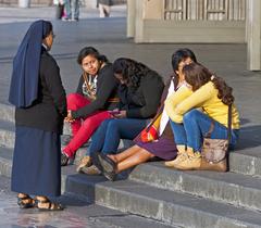 A nun talking with women on the steps of the Basilica of Our Lady of Guadalupe