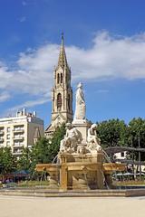 Fontaine Pradier in Nimes with the Church of Saint Perpetue and Saint Felicite