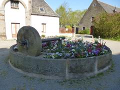 A scenic view of Le Parc de la Briantais showing expansive green lawns, lush trees, and a clear blue sky.