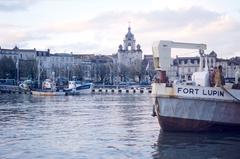 The bow of the split barge 'Fort Lupin', two trawlers in the Basin d'Échouage, and the Grosse Horloge gate in the background