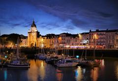 Clock tower in La Rochelle with harbor in evening view