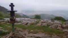 cross on Pagasarri peak with cityscape in background