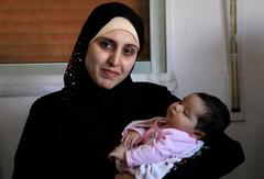 Syrian refugee woman with her newborn at an IRC clinic in Jordan