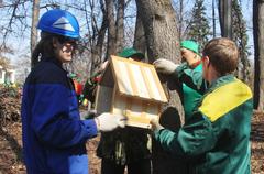 Participants of the 'Media Subbotnik' hanging a birdhouse in Neskuchny Garden