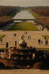 Palace of Versailles gardens with manicured lawns, statues, and water features