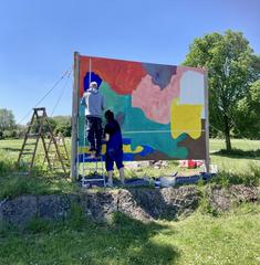 Billboard in Jardin des Deux Rives park with two artists painting