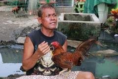 A man and his rooster in Talisay, Cebu, Philippines