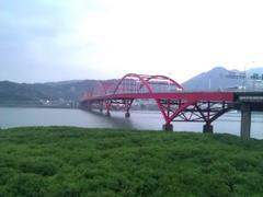 Guandu Bridge in Taiwan with its iconic red arch spanning a river