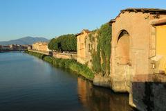 Lungarno in Pisa along River Arno with historic buildings