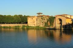 Lungarno in Pisa with picturesque buildings along the Arno River under a clear sky