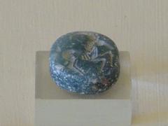 green steatite seal with engravings of a wild goat and a lion