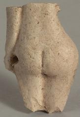 Fragment of a white clay figurine representing the buttocks of a Venus, part of an arm and thighs