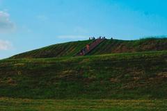 A person climbing the stairs of Cahokia Mounds on a sunny day with a clear blue sky