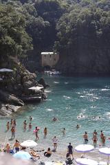 San Fruttuoso beach with clear blue waters and a historic abbey