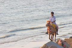 A boy riding a horse on Patenga Sea Beach