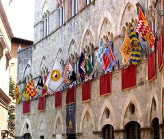 Palazzo Chigi-Saracini in Siena, Italy with flags of the Siena contrade