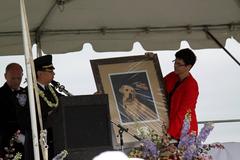 Lt. David W. Lim with a portrait of Sirius, the yellow Labrador Retriever, who was killed in the 9/11 attacks