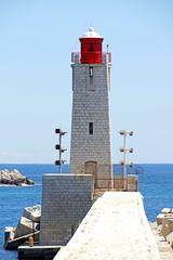 Nice Lighthouse on a square stone base with white masonry tower and red lantern