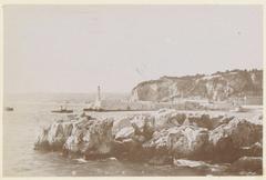 Harbor entrance with a lighthouse, likely on the coast of South France, ca. 1900-1910.