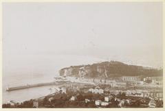 View of a harbor entrance with lighthouse, presumably on the coast of Southern France