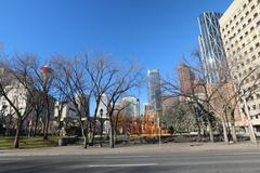 Scenic view of Calgary's urban landscape featuring pedestrians, skyscrapers, and clear sky