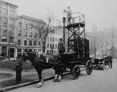 Two Montreal Light Heat & Power employees inspecting the lighting on Sainte-Anne Square with scaffolding on a cart, 1925-30