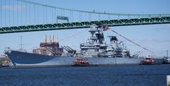 Battleship USS New Jersey being moved by tugboats on Delaware River