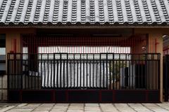 Red and black fence with kawara tile roof