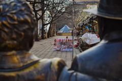 Two bronze statues of Bulgarian writers Slaveikovi overseeing a garment sale