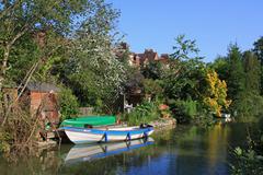 Canal in Oxford on a sunny day with houses and trees on the bank