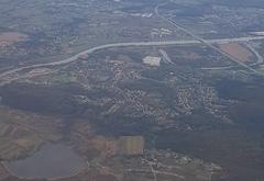 Aerial view of Tyniec, a village in Kraków, Poland, featuring the historic Tyniec Abbey surrounded by greenery and the Vistula River.