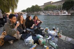 Students watching the sunset by the Seine in Paris