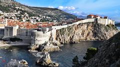 Scenic view of Dubrovnik's old town with red-roofed buildings surrounded by ancient city walls and the Adriatic Sea