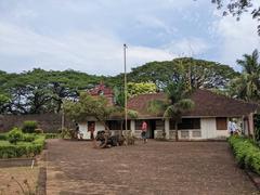 A scenic view of Thalassery beach with calm waves and a partly cloudy sky