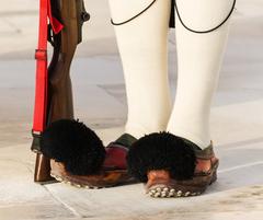 Feet of an Evzone displaying traditional footwear at the Tomb of the Unknown Soldier in Athens, Greece