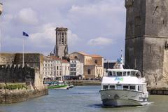 A tour boat passing between the two towers at the entrance of La Rochelle's port