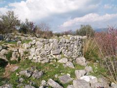 ancient stone ruins on a hillside overlooking a scenic valley