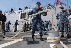 Fire Controlman Jeromy Fisher heaving a mooring line on USS Momsen