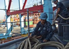 Sailor handling mooring lines on USS Tortuga